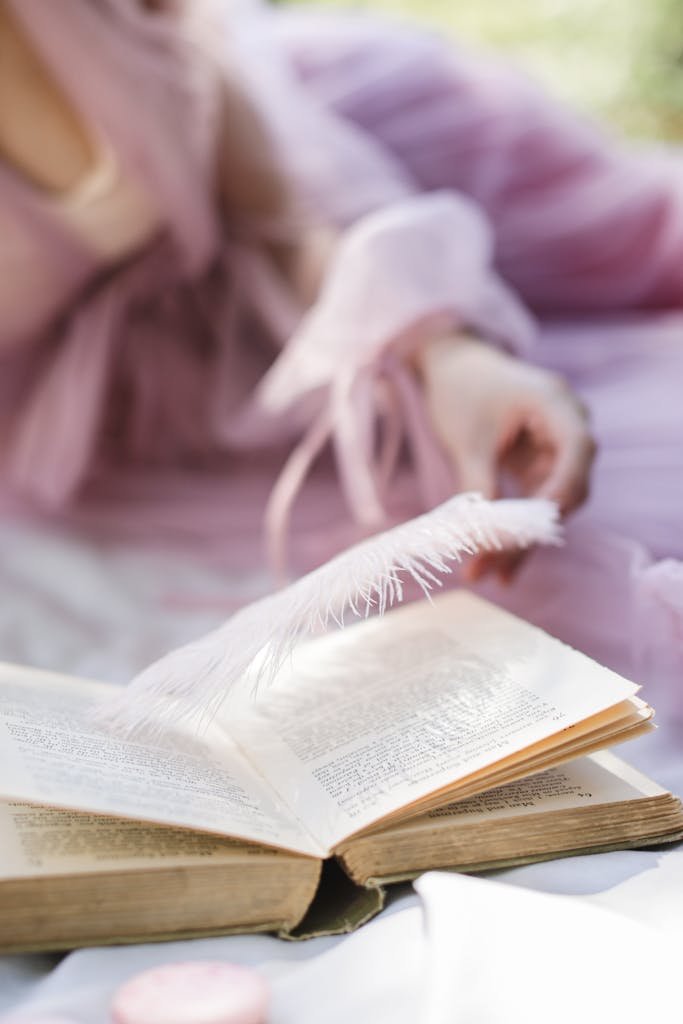 Close-up of an open book with a feather bookmark, conveying elegance and serenity.